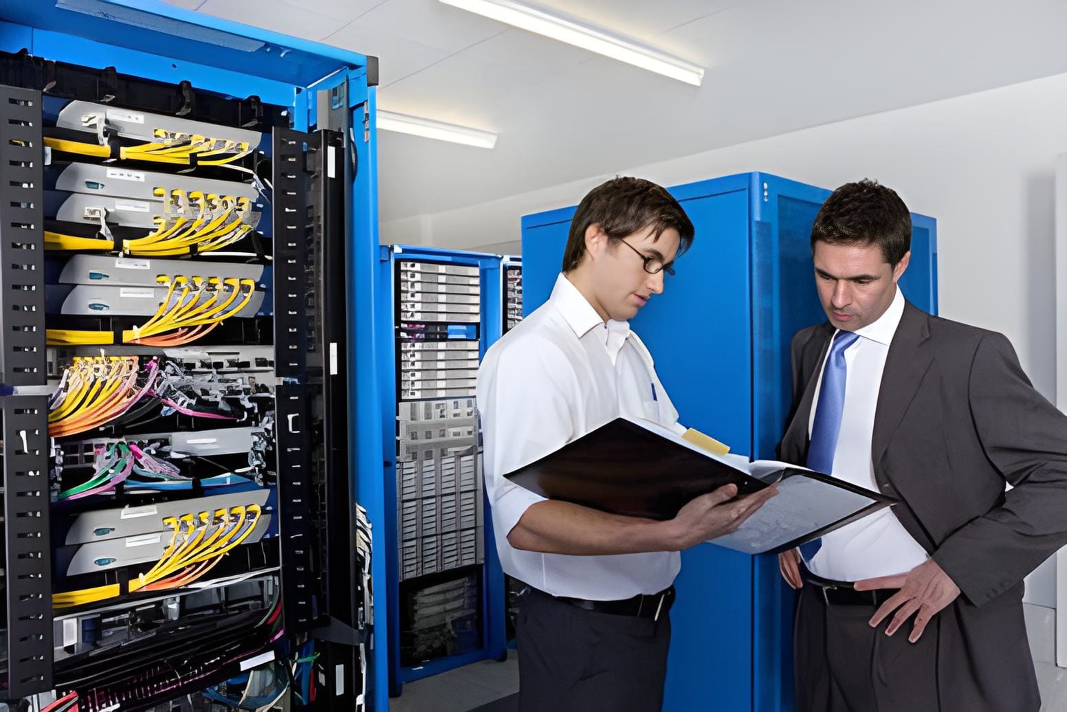Two people reviewing IT network installation documents, discussing plans and strategies.