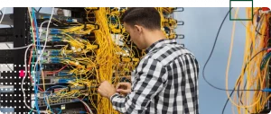 Technician troubleshooting data cables in a data rack